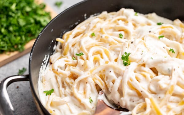 Close up view of fettuccine Alfredo in a saucepan.