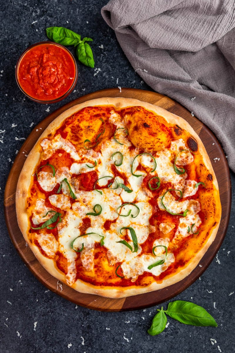 Overhead view of a whole, uncut, homemade margherita pizza.