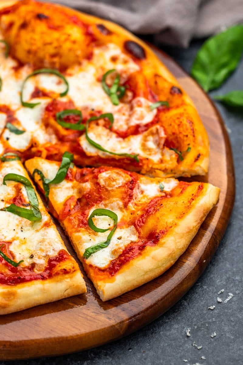 Margherita pizza on a wood pizza board.