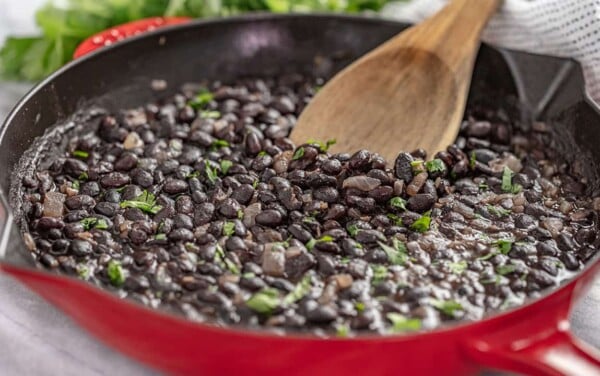 Mexican style black beans in a red skillet