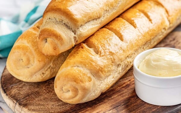 3 loaves of French bread and fresh butter in a ceramic dish