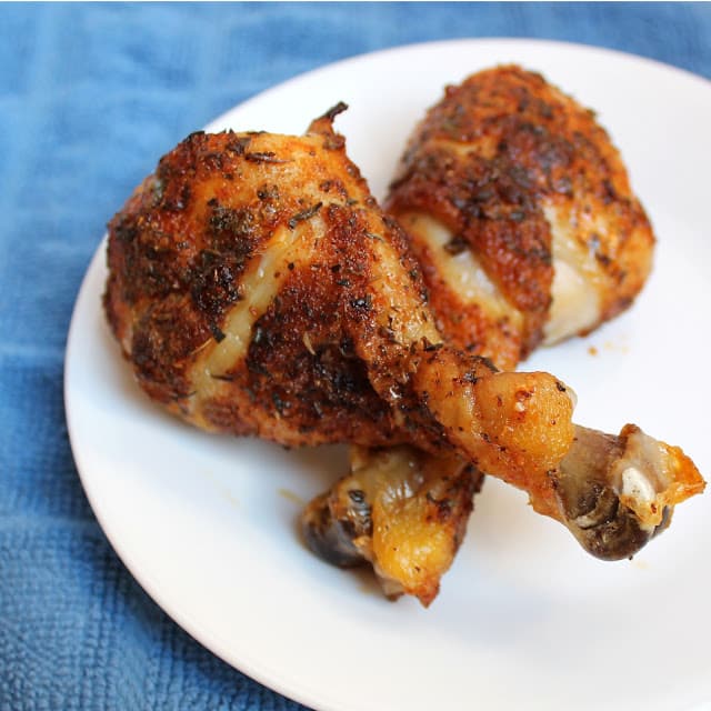 Cajun chicken drumsticks on a white plate