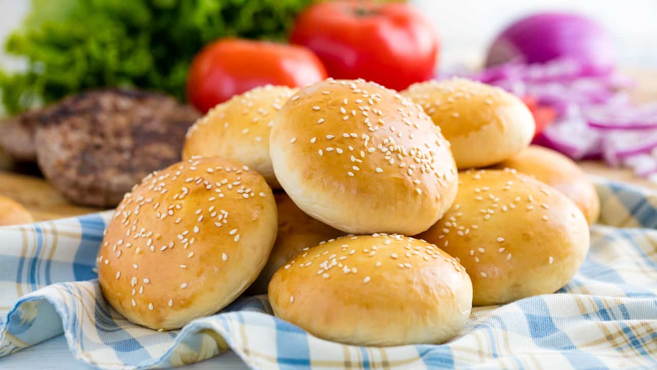 Stack of hamburger buns on a cloth.