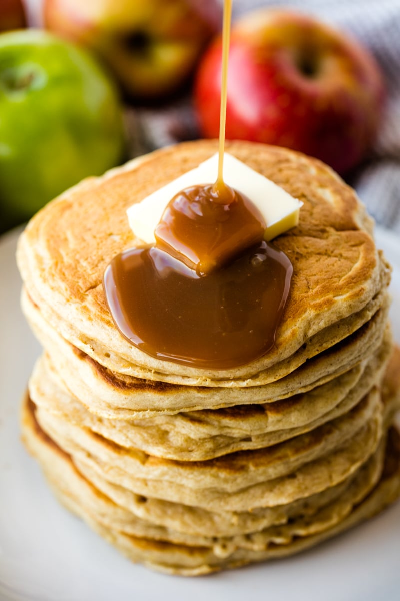 A stack of apple pancakes with butter and syrup on top.