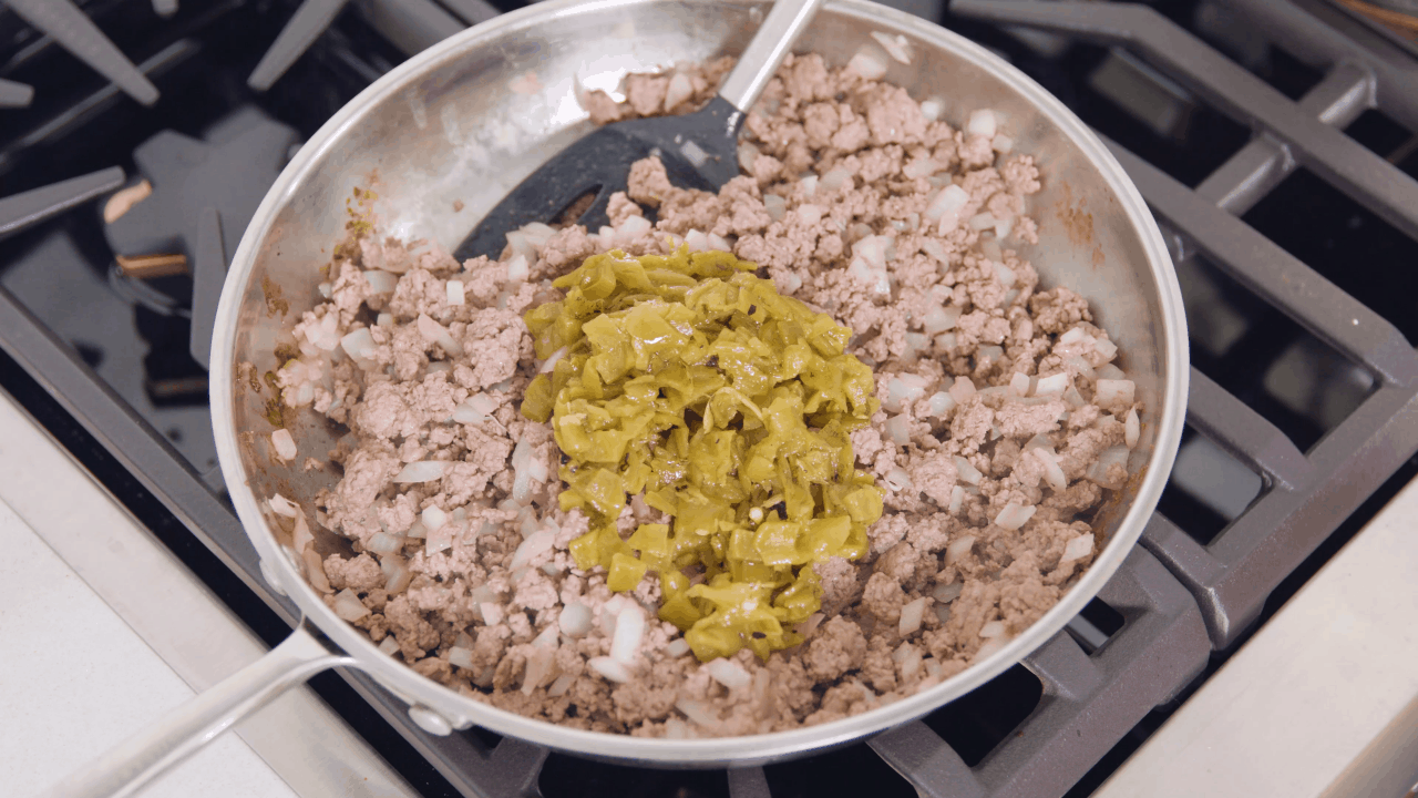 Ground Beef Enchilada Filling in a stainless steel pan on the stove.