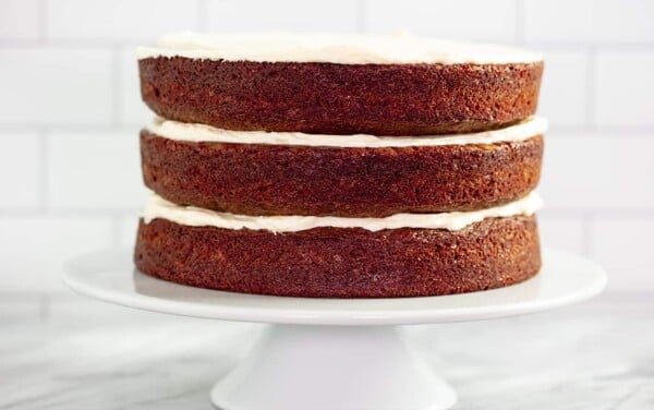 Layered Red Velvet Cake with white Ermine frosting separating each layer on a cake platter display.