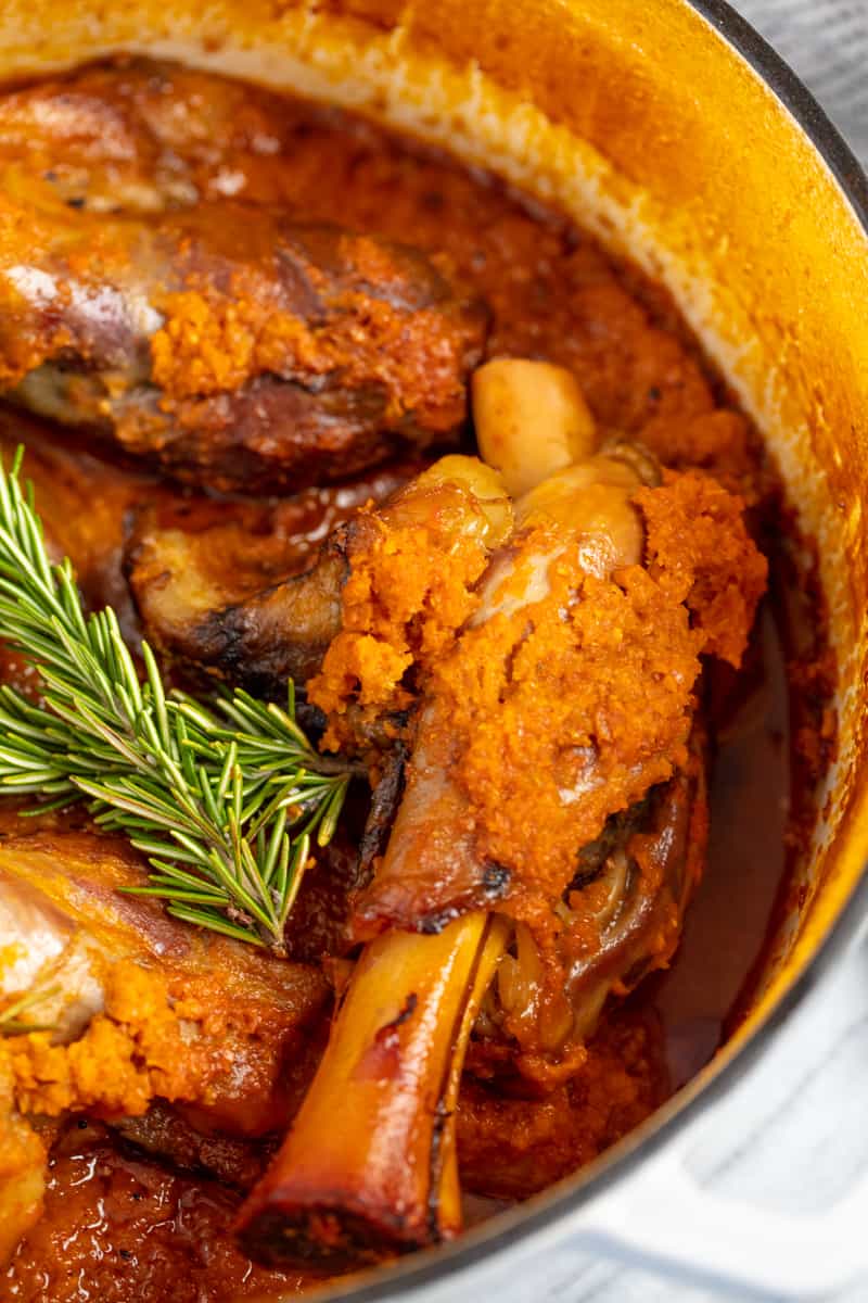 Close up of Braised Lamb Shank in a cooking pot.