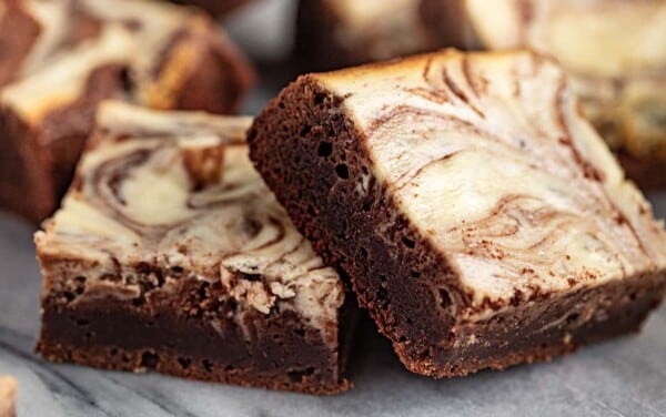 Angled view of Cheesecake Brownies cut into squares.