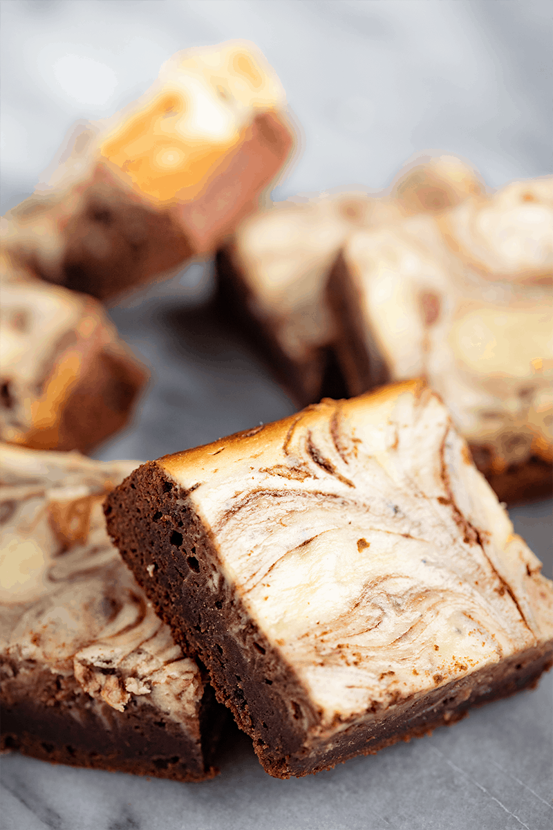 Slices of Cheesecake Brownies on a countertop.