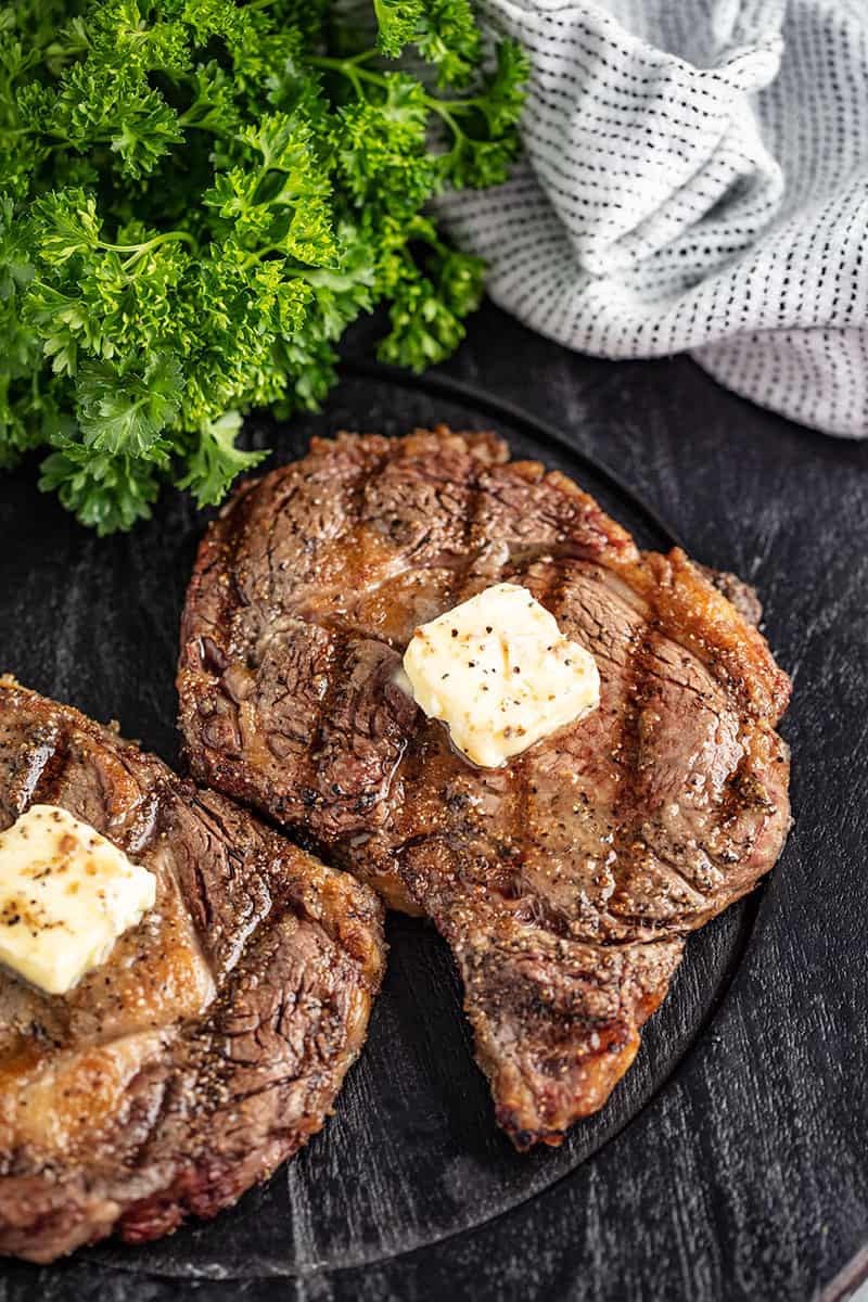 Bird's eye view of Grilled Steak with a pad of butter on it.