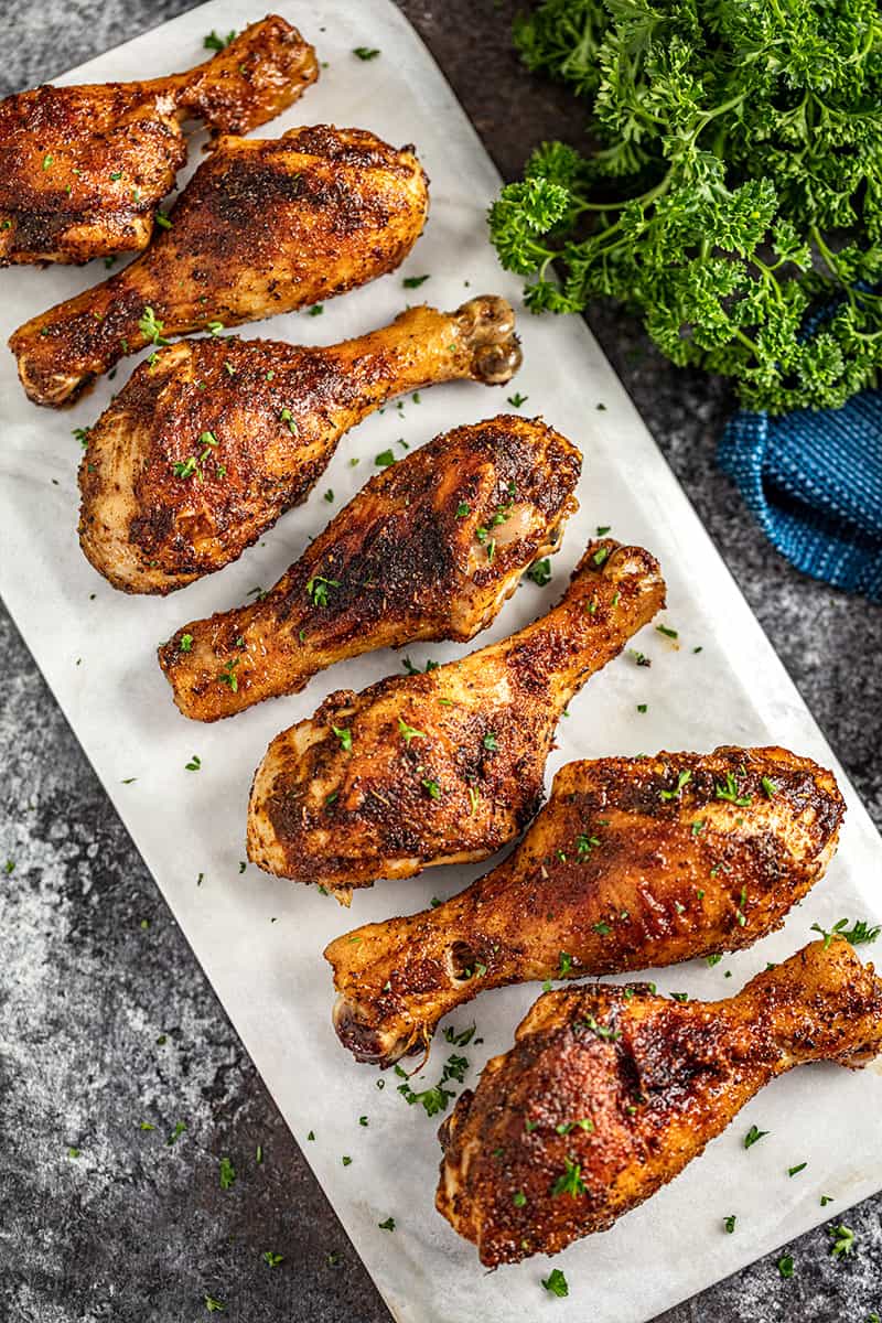 Cajun spiced chicken drumsticks lined up on a marble platter