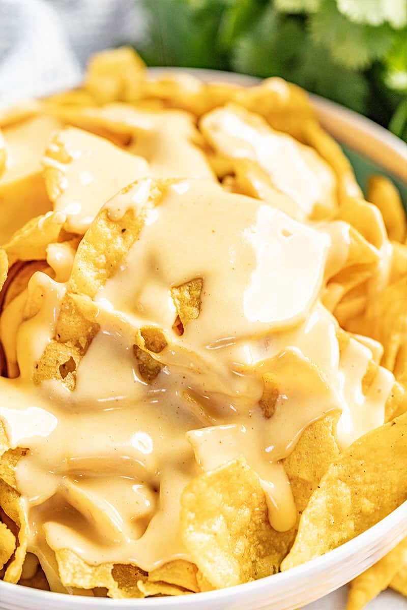 Bowl of chips coated with nacho cheese sauce