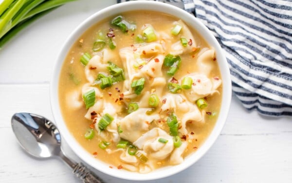 Bird's eye view of wonton soup in a white bowl.