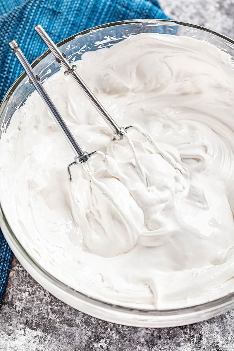 A bowl with beaters filled with 7 minute frosting.