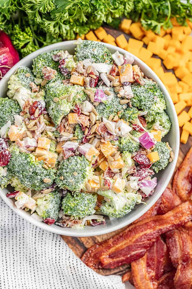 Overhead view of a large white bowl filled with broccoli salad.