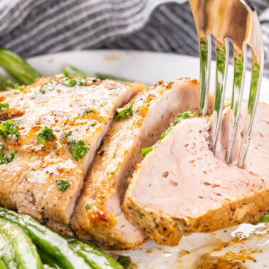 A fork stabbing into an air fryer pork tenderloin.